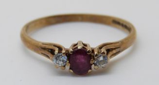 A 9ct gold ring set with an oval cut ruby and two diamonds (size M)