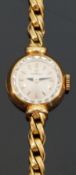 Omega 18ct gold ladies wristwatch with black hands, gold baton markers and multi-faceted bezel,