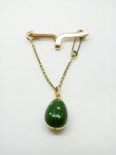 A Faberge 18ct gold and green guilloche enamel egg pendant, on 15ct brooch,