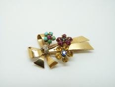 A French 18ct gold brooch set with ruby cabochons, sapphires, turquoise,