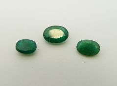 Three apple green oval cut emeralds the largest approximately 0.