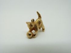 A 9ct gold charm/ pendant in the form of a cat playing with a ball, 6.