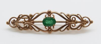 A 9ct gold brooch set with an oval emerald measuring approximately 0.75ct, 4.