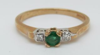 A 9ct gold ring set with a round cut emerald and two diamonds (size N)