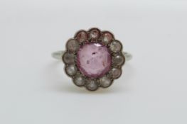 A Victorian platinum ring set with a pink sapphire to the centre surrounded by white sapphires