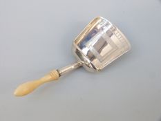 A Georgian hallmarked silver tea caddy spoon of scoop form with turned ivory handle Birmingham 1807,