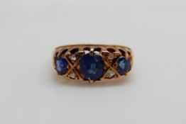 An 18ct gold ring set with three oval cut sapphires and four diamonds (size K/L)