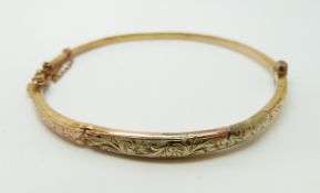 A 9ct gold bangle with engraved decoration, 4.