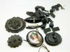 A jet brooch with carved musical instruments, a faceted jet necklace,