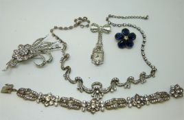 A silver floral brooch set with paste, a paste bracelet,
