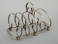 An Edward VII hallmarked silver four division toast rack, Birmingham 1905 maker William Devenport,