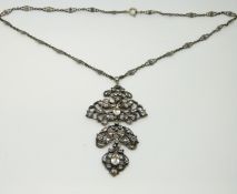 A silver necklace set with paste in a floral design,