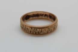 A 9ct gold wedding band with textured decoration, 3.