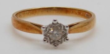 An 18ct gold ring set with a round cut diamond in a star setting, 2.