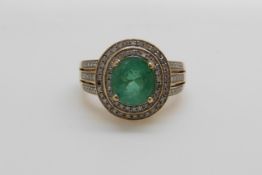 A 14ct gold ring set with an oval cut emerald of approximately 1.