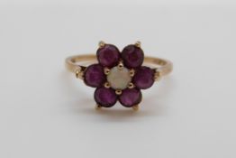 A 9ct gold ring set with an opal surrounded by rubies, 2.