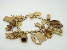A 9ct gold charm bracelet with a large quantity of 9ct gold charms including cheque book,
