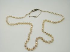 A single strand pearl necklace with a silver and marcasite clasp