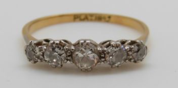 An 18ct gold ring set with five diamonds in a platinum setting, largest diamond approximately 0.