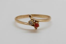 A yellow metal ring set with a diamond and a coral cabochon (size T)