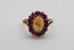 An 18ct gold Victorian ring set with an oval black cabochon surrounded by rubies (size K)