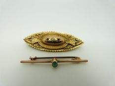 A late 19th/ early 20thC 9ct gold brooch set with a diamond and two garnets verso a glass