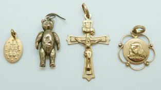 A 9ct gold teddy bear pendant, a 9ct gold cross pendant and two 9ct gold religious pendants, 4.