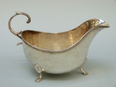 An American white metal sauce boat raised on three feet, marked to underside Birks Sterling 85,