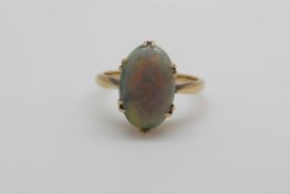 An 18ct gold ring set with an opal cabochon (size I/J)