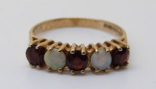 A 9ct gold ring set with garnets and opals (size I)