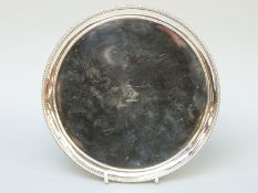 A George III hallmarked silver three footed circular salver with beaded rim, London 1782,