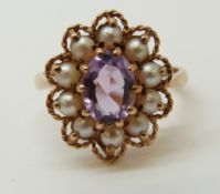 A 9ct gold ring set with an amethyst and surrounded with pearls (size N)