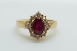 An 18ct gold ring set with an oval cut ruby of approximately 0.75ct surround by diamonds, 4.