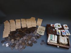 A quantity of mainly copper coins together with sets of 1930s cigarette cards in an oak box,