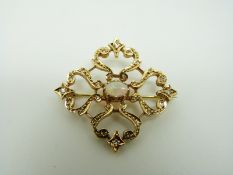 An 18ct gold brooch set with an opal cabochon to the centre surrounded by diamonds, 3.
