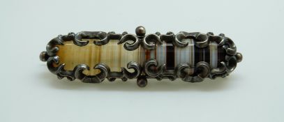 A silver brooch set with a section of banded agate,