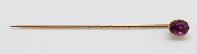 A yellow metal stick pin set with an oval ruby measuring approx 1ct,