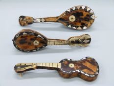 Three tortoiseshell and mother of pearl mandolins/guitars