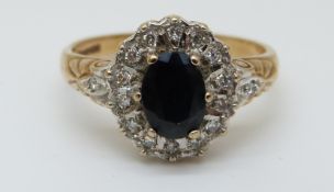 A 9ct gold ring set with an oval sapphire surrounded by diamonds (size M)