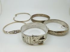 Five silver bangles including a Victorian buckle bangle