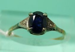 A 9ct gold ring set with an oval sapphire and two diamonds (size K)