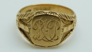 An 18ct gold signet ring with textured foliate decoration to the shoulders, 10.
