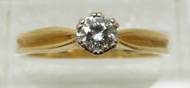 An 18ct gold ring set with a round cut diamond of approximately 0.