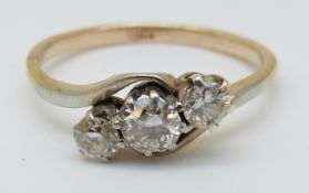 An 18ct gold ring set with three diamonds in a twist setting, the largest diamond approximately 0.