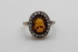 A Victorian ring set with an oval cut citrine surrounded by rose cut diamonds (size P)