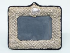 A modern easel back hallmarked silver embossed photograph frame to suit 6x4
