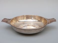A hallmarked silver shallow porringer with pierced handles,