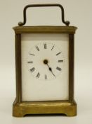An early 20thC brass carriage clock in corniche style case, enamelled Roman dial,