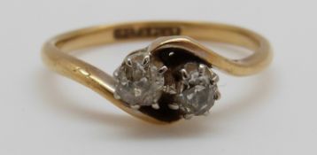 An 18ct gold ring set with two diamonds in a twist setting,