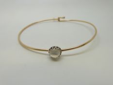 A yellow metal bangle set with a moonstone cabochon, 5.